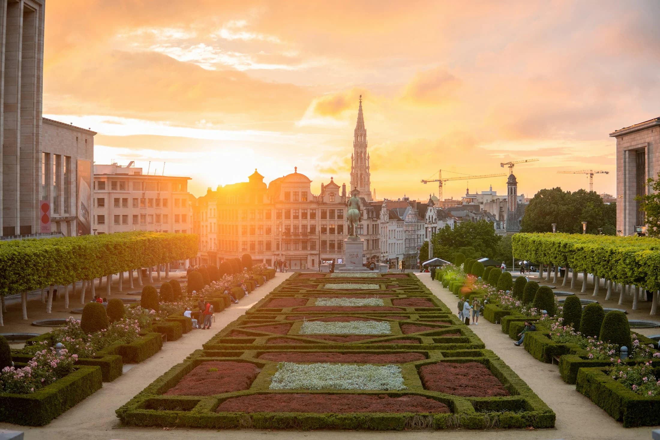 The Mont des Arts gardens and the Brussels Town Hall spire in the warm evening light.